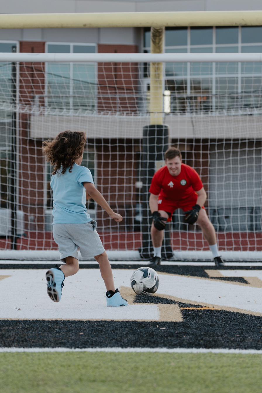 A young supporter taking a penalty at halftime